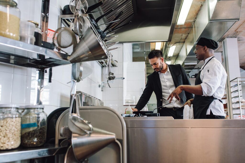 Restaurant owner with chef in kitchen