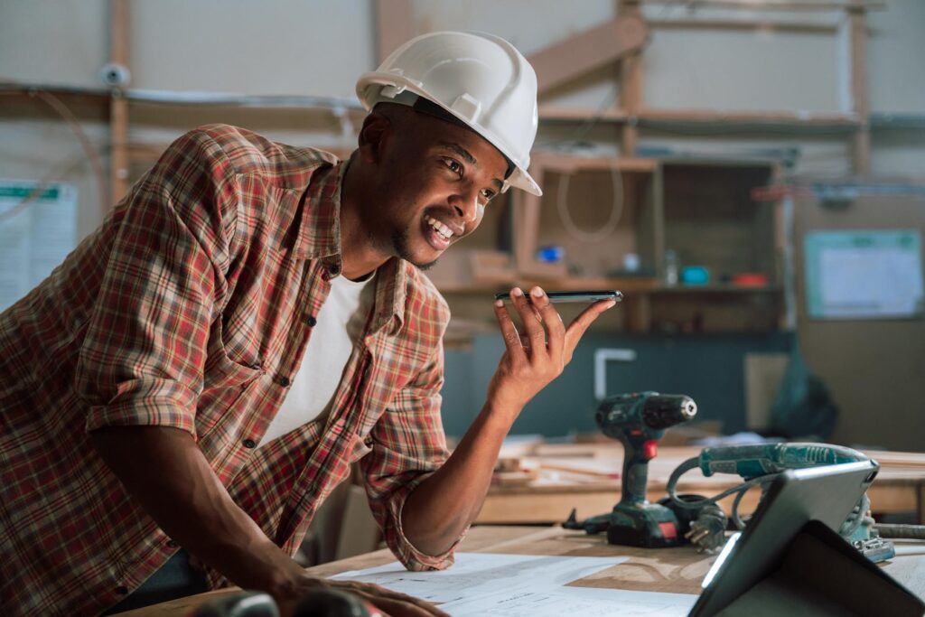 Medium shot of male talking on the phone in a carpentry factory